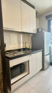 a kitchen with white cabinets and a stainless steel refrigerator at The base Central Pattaya 903 by Numam in Pattaya Central
