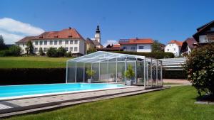 une serre autour d'une piscine dans une cour dans l'établissement Haus Rose, à Wenigzell