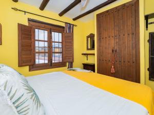 a bedroom with a large white bed and a window at Cubo's Casa Mas Axarquia BBQ Roof Terrace in Sedella