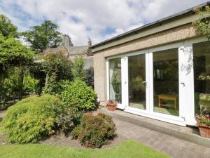 a house with large sliding glass doors at Abbeyside Cottage in Kelso
