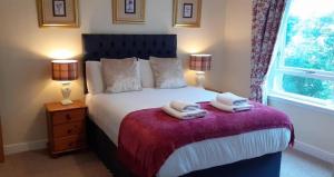 a bedroom with a bed with two towels on it at Abbeyside Cottage in Kelso