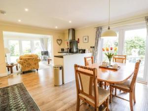 a kitchen and dining room with a table and chairs at Abbeyside Cottage in Kelso