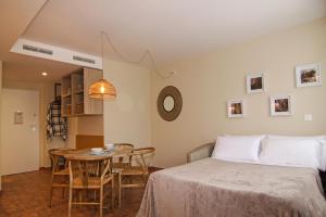 um quarto com uma cama e uma mesa com cadeiras em Apartamentos Las Ciencias Studio M em Valência