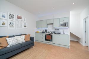 een woonkamer met een bank en een keuken bij Skyline Serviced Apartments - Julians Road in Stevenage