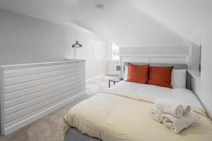 a bedroom with a large white bed with towels on it at Skyline Serviced Apartments - Julians Road in Stevenage