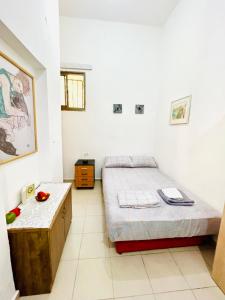 a bedroom with a bed and a table in it at Уютная Квартира 1,5 комнаты. in Haifa