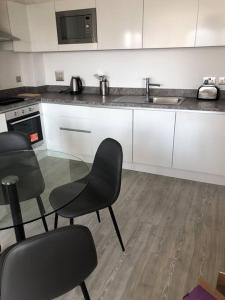 a kitchen with a table and chairs and a sink at 3 bedroom apartment free parking in Manchester
