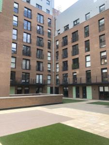 an empty courtyard in front of a large building at 3 bedroom apartment free parking in Manchester