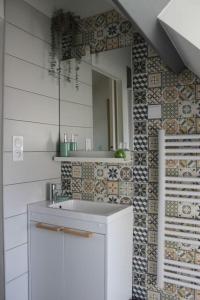 Fresnay-sur-SartheにあるMaison rénovée Atoué locのバスルーム(白い洗面台、鏡付)
