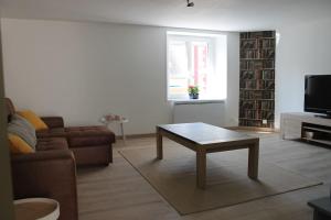 - un salon avec un canapé et une table basse dans l'établissement Maison rénovée Atoué loc, à Fresnay-sur-Sarthe