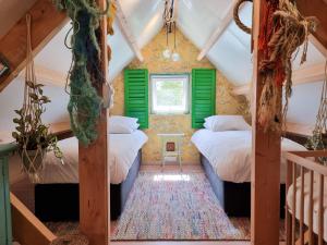 twee bedden in een kamer met groene luiken bij Vakantiehuis Dishoek DI04 in Dishoek