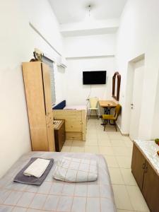een kamer met een bed, een bureau en een televisie bij Уютная Квартира 1,5 комнаты. in Haifa