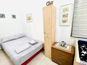 a small bedroom with a bed and a wooden cabinet at Уютная Квартира 1,5 комнаты. in Haifa