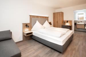 - une chambre avec un lit et un canapé dans l'établissement Landgasthof Maier, à Vilsbiburg