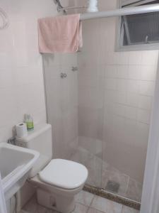 bagno bianco con servizi igienici e doccia di Loft encantador centro Guarapari a Guarapari