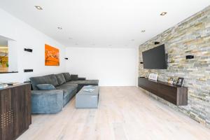 a living room with a couch and a brick wall at Alpin Chalet Arte in Söll