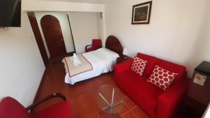 チャチャポヤスにあるCasa Kuelap Hostalのベッドルーム1室(ベッド1台、赤いソファ付)