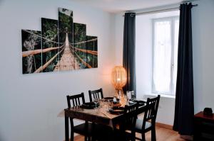 a dining room with a table and a picture of a bridge at Dormir à Brioude - appartement 'esprit nature' in Brioude