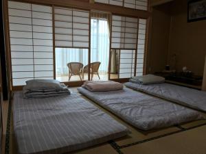 菊川市SOZENSYA 駅、高速インターに近い新築日本家屋です。庭が広く、BBQも楽しめます。的带窗户的客房内设有三张床。