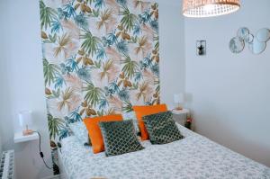 a bedroom with a bed with a tropical wallpaper at Dormir à Brioude - appartement 'esprit nature' in Brioude