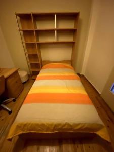 a bedroom with a bed with an orange and yellow stripes at Cute 2bdrm in Salonica Center in Thessaloniki