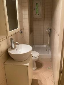 a white bathroom with a sink and a toilet at Cute 2bdrm in Salonica Center in Thessaloniki