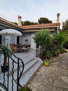 a patio with a bench and a table with an umbrella at La Med in Carry-le-Rouet