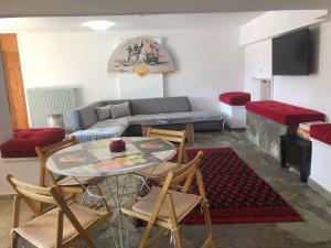 Sfiris Resort في إيلاتي تريكالون: غرفة معيشة مع طاولة وكراسي وأريكة