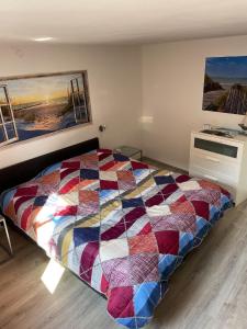 a bedroom with a colorful quilt on a bed at 2 bedrooms appartement with wifi at Charleroi in Charleroi