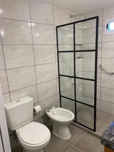 a bathroom with a toilet and a glass shower at Esquel Home in Esquel