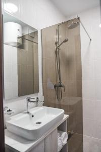 a white bathroom with a sink and a shower at Вілла Край неба in Zapson