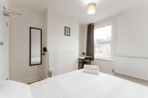 a white bedroom with a large bed and a window at Great Rooms in Plaistow in London +31 photos