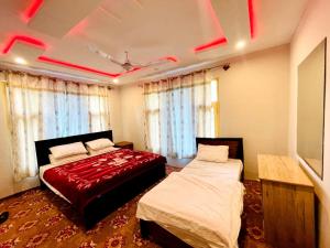 Serene Guest House في سكردو: سريرين في غرفة ذات إضاءة حمراء
