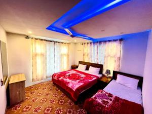 Serene Guest House في سكردو: غرفة نوم بسريرين واضاءة زرقاء