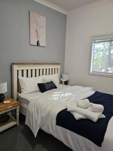 Un dormitorio con una gran cama blanca y una ventana. en Oceanfront Odyssey, en Portarlington