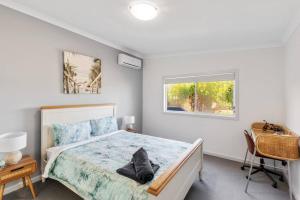 un dormitorio con una cama y una ventana en Oceanfront Odyssey, en Portarlington