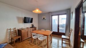 a dining room with a table and chairs and a television at Apartamentos Grifovacances Nevada in Pas de la Casa