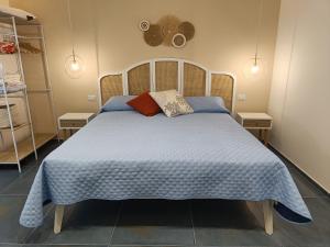 a bedroom with a bed with a blue comforter and pillows at Villa sulla spiaggia Donnalucata in Ragusa