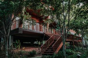 a house with a staircase in the middle of trees at De Foret in Havelock Island