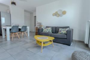 una sala de estar con un sofá y una mesa en Le Nid des Romains - T2 neuf - Balcon - vue, en Annecy 13 fotos más