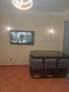 Habitación con mesa y TV en la pared. en بورتو السخنه en Ain Sokhna