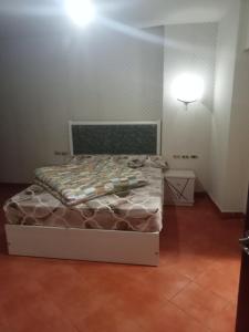 1 dormitorio con 1 cama y una luz en la pared en بورتو السخنه en Ain Sokhna