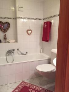 La salle de bains est pourvue de toilettes, d'une baignoire et d'une serviette pour le cœur. dans l'établissement La casetta di Crans, à Crans-Montana