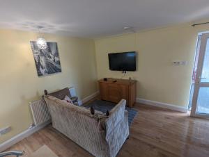 a living room with two couches and a flat screen tv at Antrim Heights BnB in Antrim