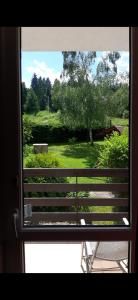 ventana con vistas a un parque con banco en Guest House U Sester, en Skhidnytsya