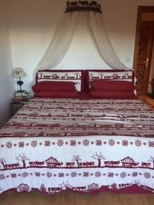 a bedroom with a bed with a red and white bedspread at La casetta di Crans in Crans-Montana