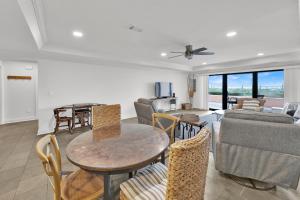 una sala de estar con una mesa y sillas en Aegean 104 - Updated Aegean Gulf Front Property, en Destin