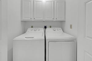 una cocina con armarios blancos y 2 electrodomésticos blancos en Aegean 120 - Beach Front 2 Bedroom, en Destin 28 fotos más