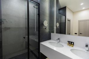 a bathroom with two sinks and a shower at Amsterdam Hotel Aktobe in Aktobe