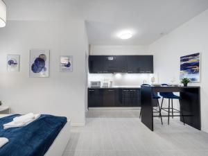 sypialnia z łóżkiem i biurkiem oraz kuchnia w obiekcie Central and New apartment with AC w Budapeszcie